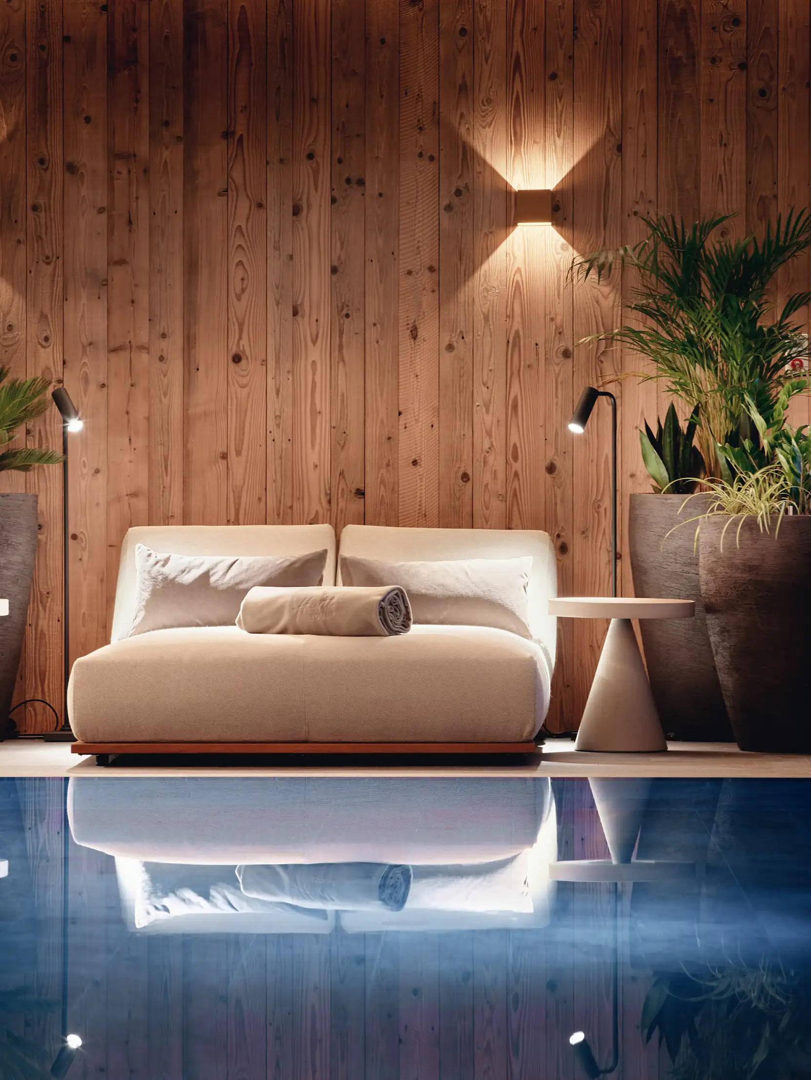 Elegante Lounge mit Sofa und Pflanzen am Pool